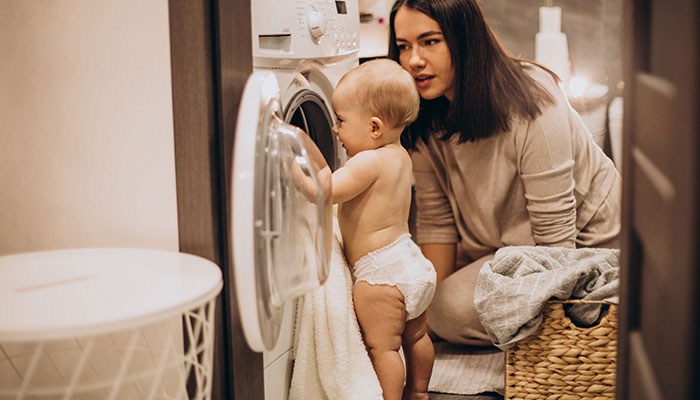 مادر و کودک در حال بررسی ماشین لباسشویی و انتخاب بهترین شوینده برای کودک